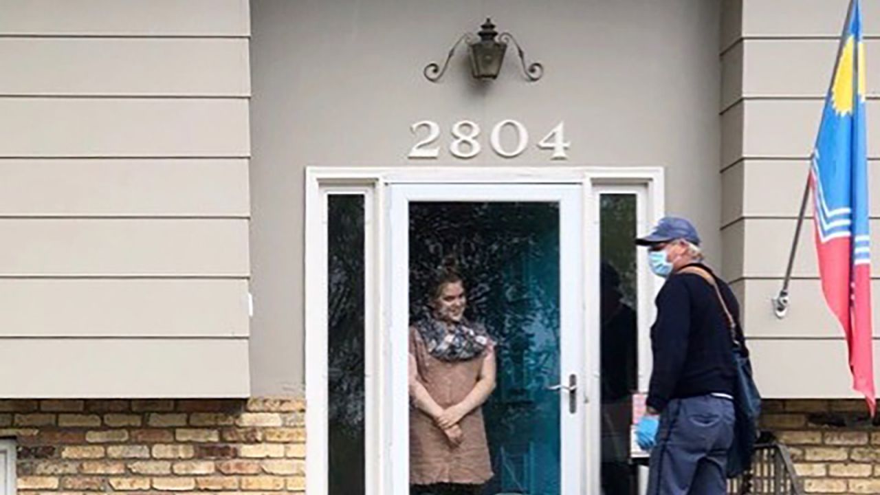 Emerson greets her mail carrier, Doug Scott, at her front door.