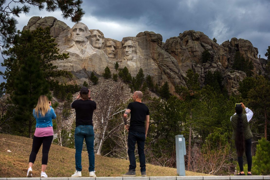 Tourists take photos of Mount Rushmore National Memorial on April 23 in Keystone, South Dakota.