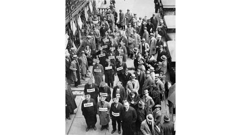 Wearing signs offering to work for a dollar a week, unemployed people demonstrate in Times Square, New York, in November 1930.