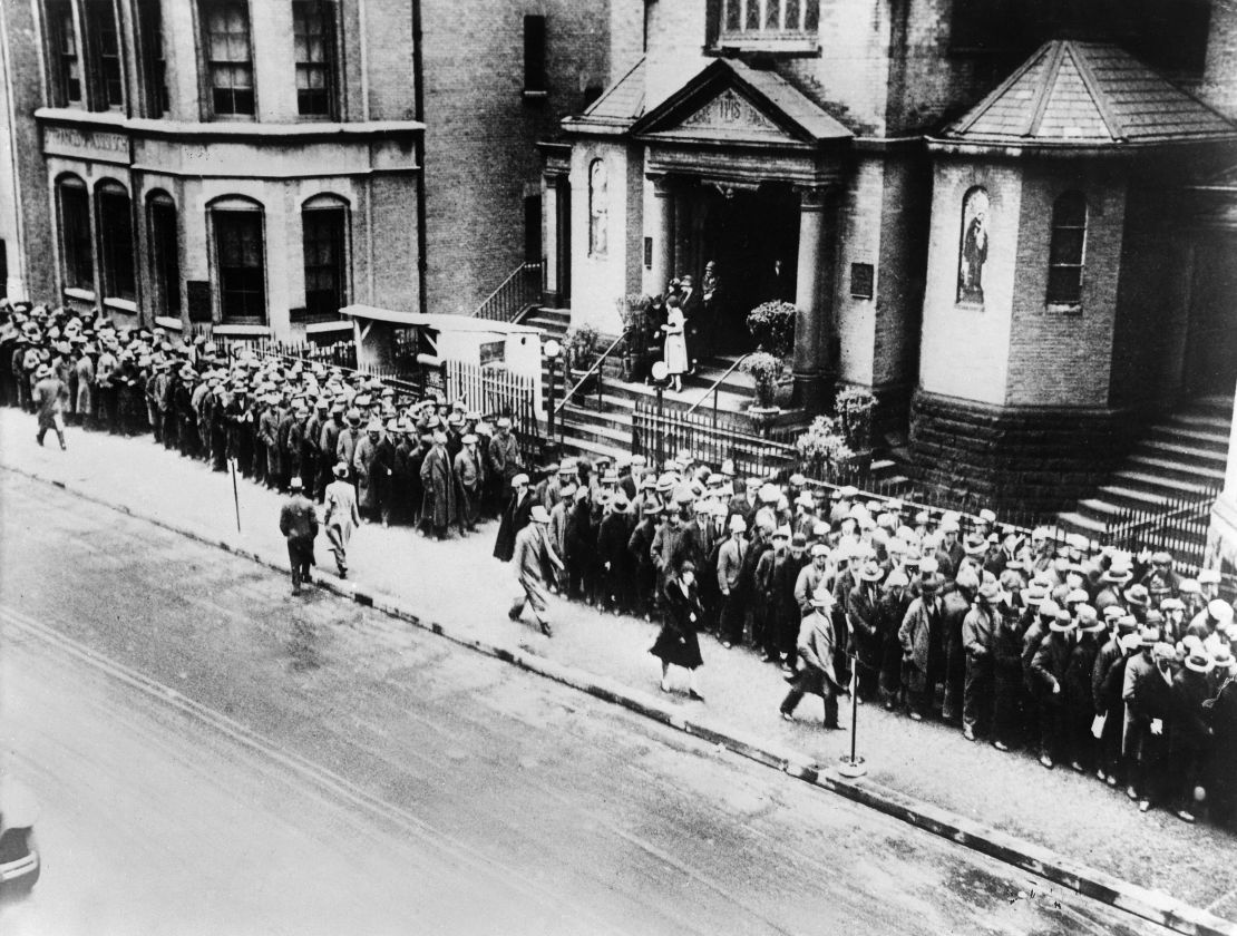 Unemployed workers line up for free meals in 1930 at a Franciscan church in New York City.