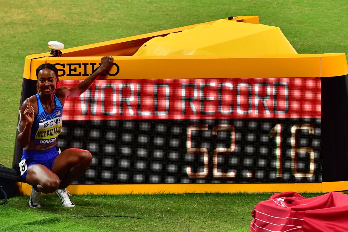 Muhammad poses next to the screen reading the new world record she set in the Women's 400m hurdles at the 2019 IAAF Athletics World Championships at the Khalifa International stadium.