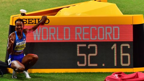 Muhammad poses next to the screen reading the new world record she set in the Women's 400m hurdles at the 2019 IAAF Athletics World Championships at the Khalifa International stadium.