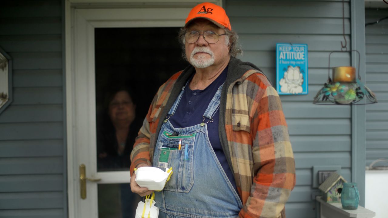 Dennis Ruhnke holds two of his remaining N-95 masks as he stands with his wife, Sharon at their home near Troy, Kan. Friday, April 24, 2020. Dennis, a retired farmer, shipped one of the couple's five masks left over from his farming days to New York Gov. Andrew Cuomo for use by a doctor or a nurse. (AP Photo/Charlie Riedel)