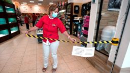 Store manager Natalie Hijazi temporarily closes off the entrance to a Pet Fair store inside The Woodlands Mall to help meet the current occupancy limits in place Tuesday, May 5, 2020, in The Woodlands, Texas. The mall reopened Tuesday with increased health and safety measures in place.Texas' stay-at-home orders due to the COVID-19 pandemic have expired and Texas Gov. Greg Abbott has eased restrictions on many businesses that have now opened. (AP Photo/David J. Phillip)