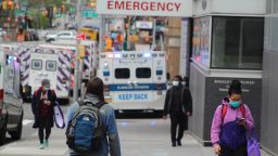 April 17, 2020, New York, New York, USA: These passers-by wear a mask on the sidewalk in the middle of a lot of ambulances, alongside Bellevue Hospital in New York. (Credit Image: ? Marie Le Ble/ZUMA Wire)