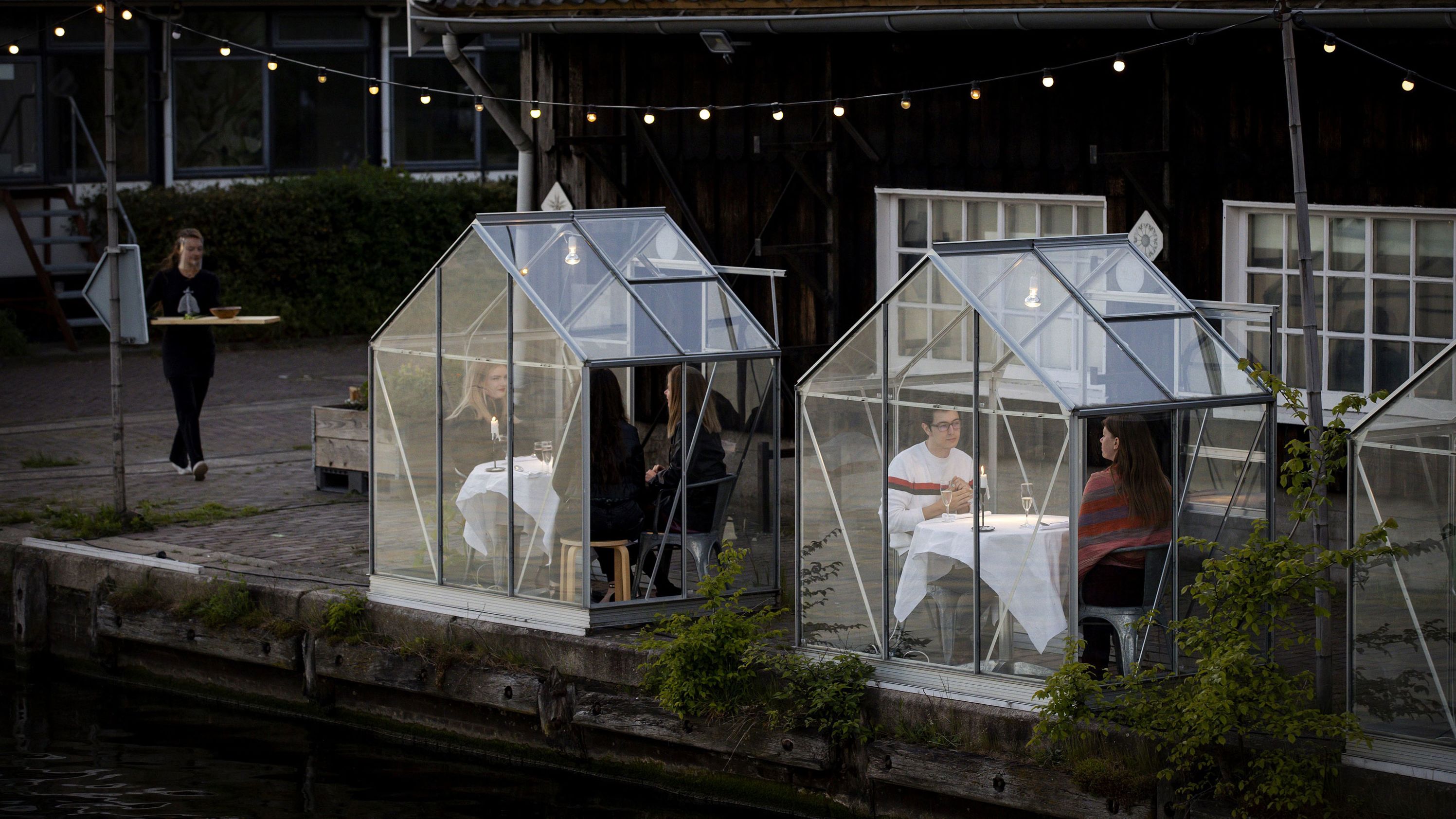 People have dinner in a so-called quarantine greenhouses in Amsterdam, on May 5, 2020 as the country fights against the spread of the COVID-19, the novel coronavirus. 