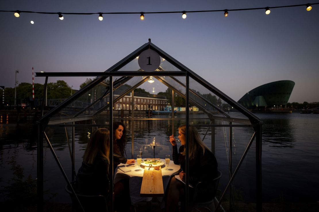 A group of friend have dinner in a so-called quarantine greenhouses in Amsterdam, on May 5, 2020 as the country fights against the spread of the COVID-19, the novel coronavirus.
