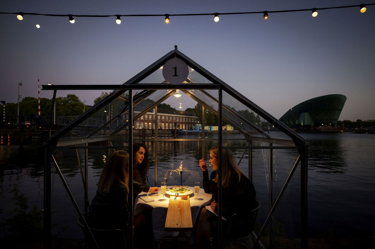 A group of friend have dinner in a so-called quarantine greenhouses in Amsterdam, on May 5, 2020 as the country fights against the spread of the COVID-19, the novel coronavirus.