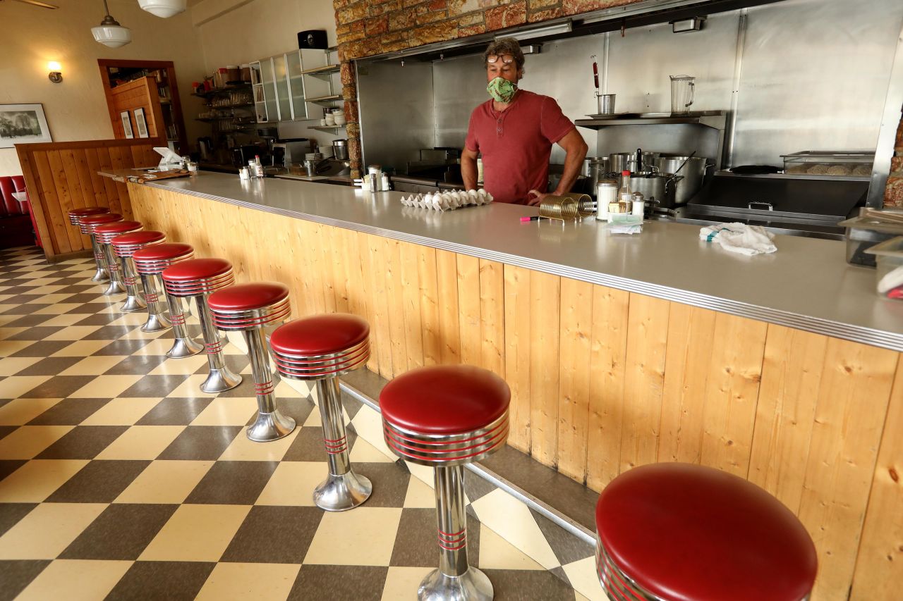 Travis Medlock, owner of the Little Shop of Ramen, looks over a row of empty stools inside his restaurant in Mariposa, California, on April 29. During the coronavirus pandemic, Medlock now only takes orders to go. 