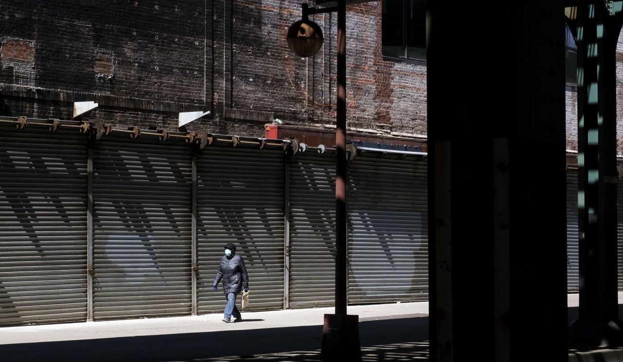 A person walks past shuttered storefronts in the Bronx as all nonessential businesses in New York were ordered closed during the pandemic. 