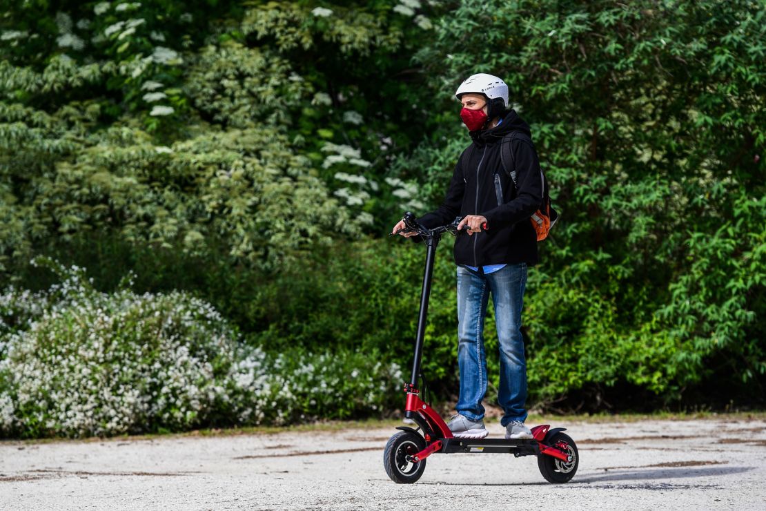 A man rides an electric scooter across the Parco Sempione park in Milan.
