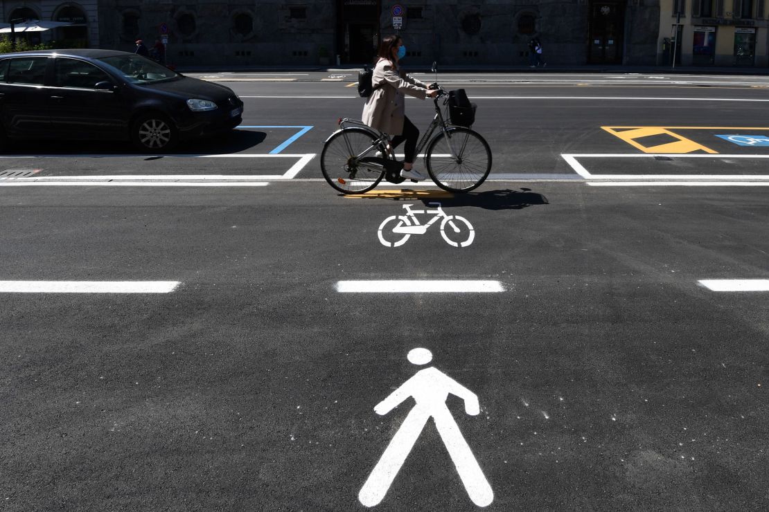 A woman cycles through a bike lane in Milan.