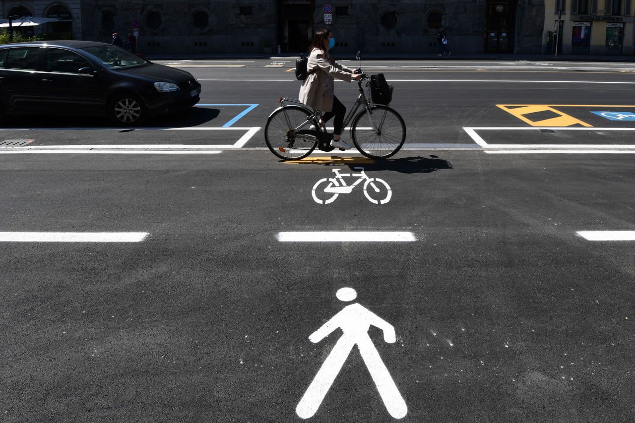 A woman cycles through a bike lane in central Milan.