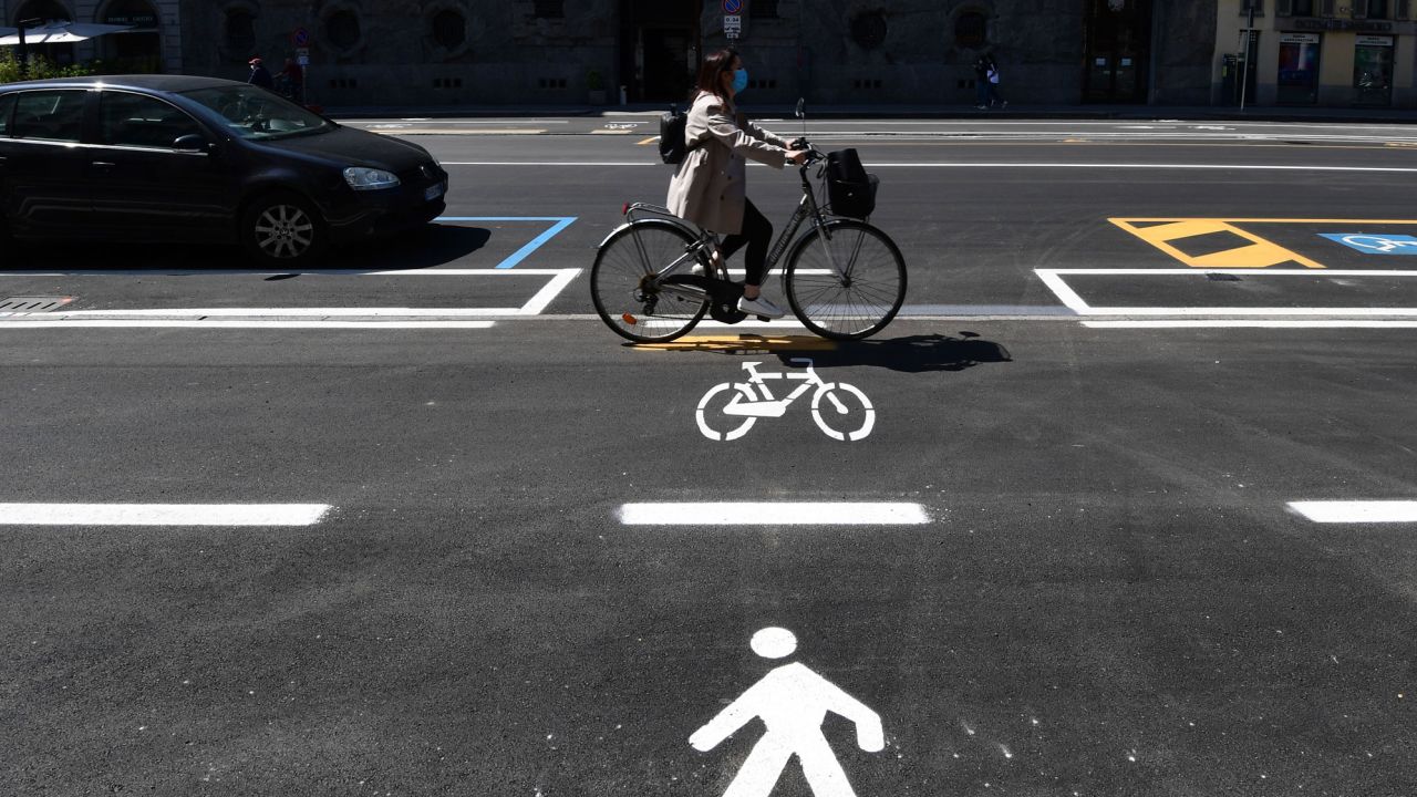 A woman cycles through a bike lane in Milan.