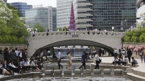 People relax at the Cheonggye Stream in the South Korean capital, Seoul, on Thursday amid a lifting of restrictions in the wake of the coronavirus pandemic.