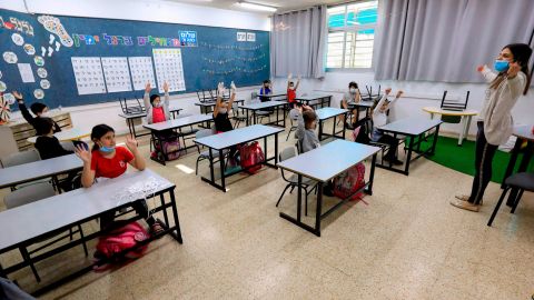 An Israeli teacher welcomes students back to class along with new measures to prevent coronavirus spread. 