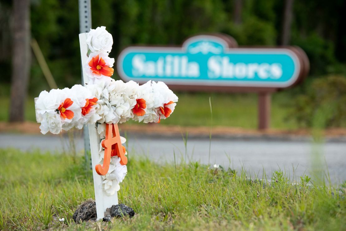 A cross with flowers and a letter "A" sits at the entrance to the Satilla Shores neighborhood where Ahmaud Arbery was shot and killed in Brunswick, Georgia.
