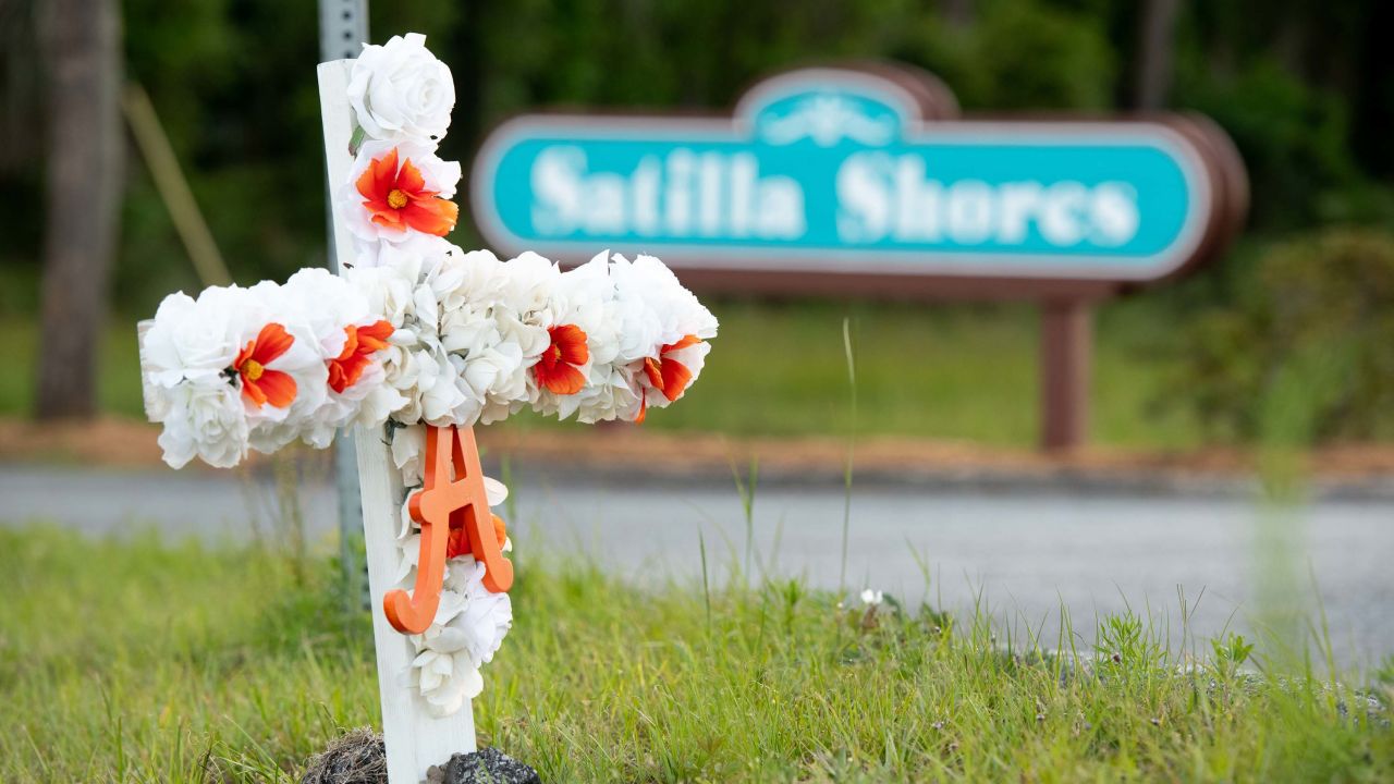 A cross with flowers and a letter "A" sits at the entrance to the Satilla Shores neighborhood where Ahmaud Arbery was shot and killed in Brunswick, Georgia. 
