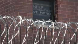 CHICAGO, ILLINOIS - APRIL 09: A sign pleading for help hangs in a window at the Cook County jail complex on April 09, 2020 in Chicago, Illinois. With nearly 400 cases of COVID-19 having been diagnosed among the inmates and employees, the jail is nation's largest-known source of coronavirus infections. (Photo by Scott Olson/Getty Images)
