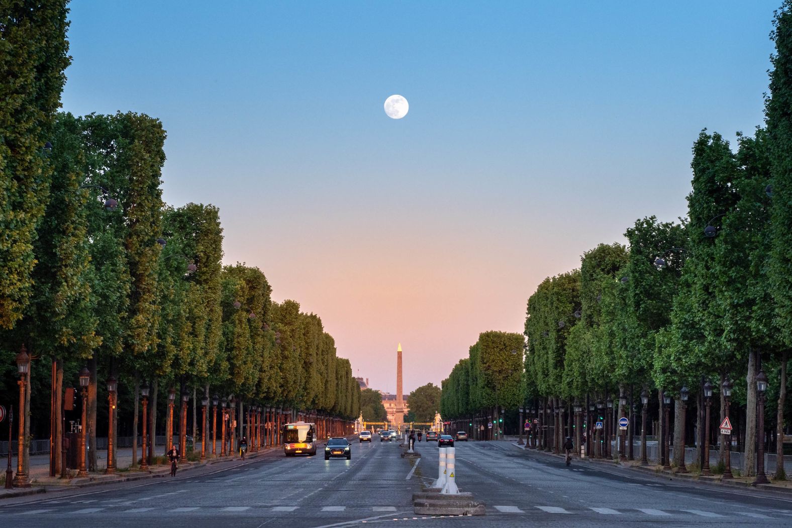 The moon is seen in Paris over the Place de la Concorde. 