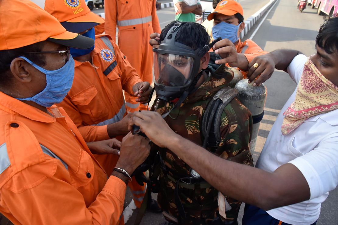 A member of India's National Disaster Response Force (NDRF) is fitted with protective gear before he enters the area affected by the leak.