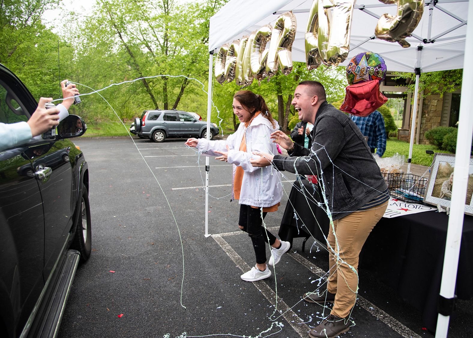 Twins Abby and Austin Angel get sprayed with Silly String at <a href="index.php?page=&url=https%3A%2F%2Fwww.knoxnews.com%2Fstory%2Flife%2F2020%2F04%2F27%2Fclass-2020-knoxville-family-hosts-drive-through-graduation-party-after-coronavirus-cancels-ceremony%2F3030545001%2F" target="_blank" target="_blank">their drive-thru graduation party</a> in Knoxville, Tennessee, on April 26. They had just graduated from high school.