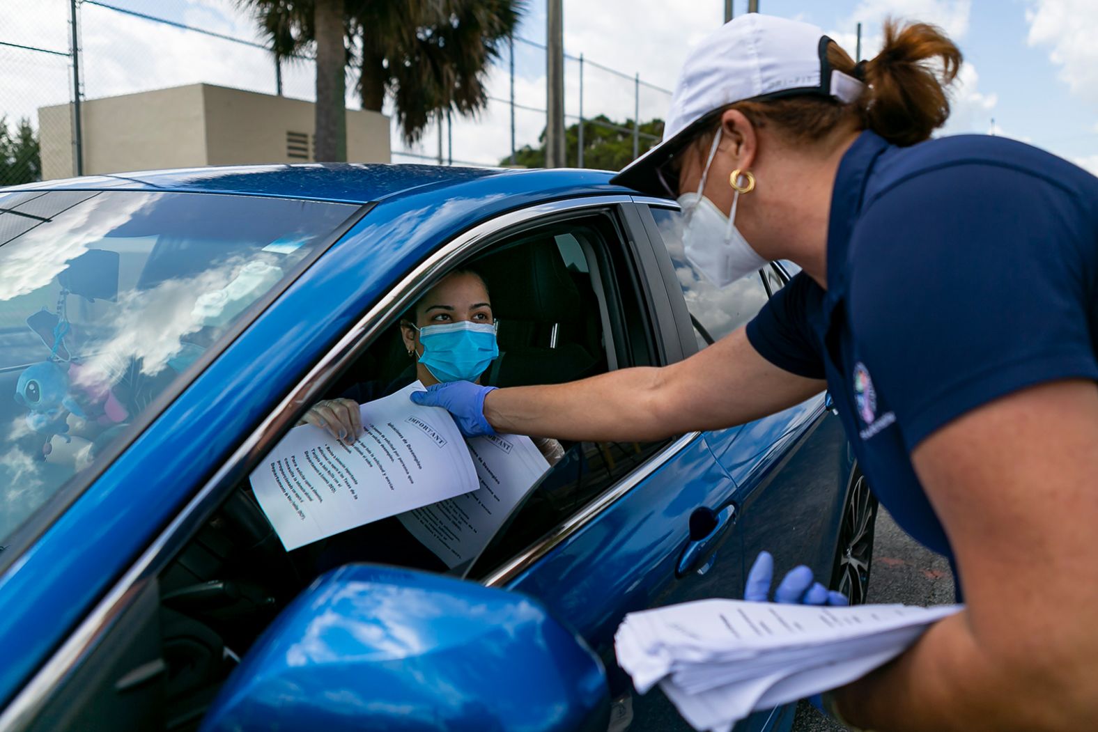 City employee Tatiana Fernandez distributes unemployment forms outside the John F. Kennedy Library in Hialeah, Florida, on April 7.