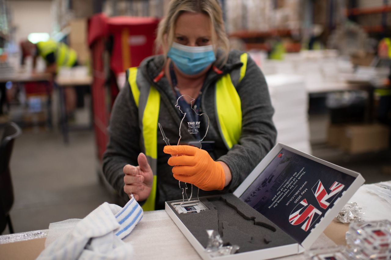 A factory worker in Aylesford, England, prepares commemorative figures for VE Day while wearing personal protective equipment to guard against the coronavirus on Tuesday, May 5.