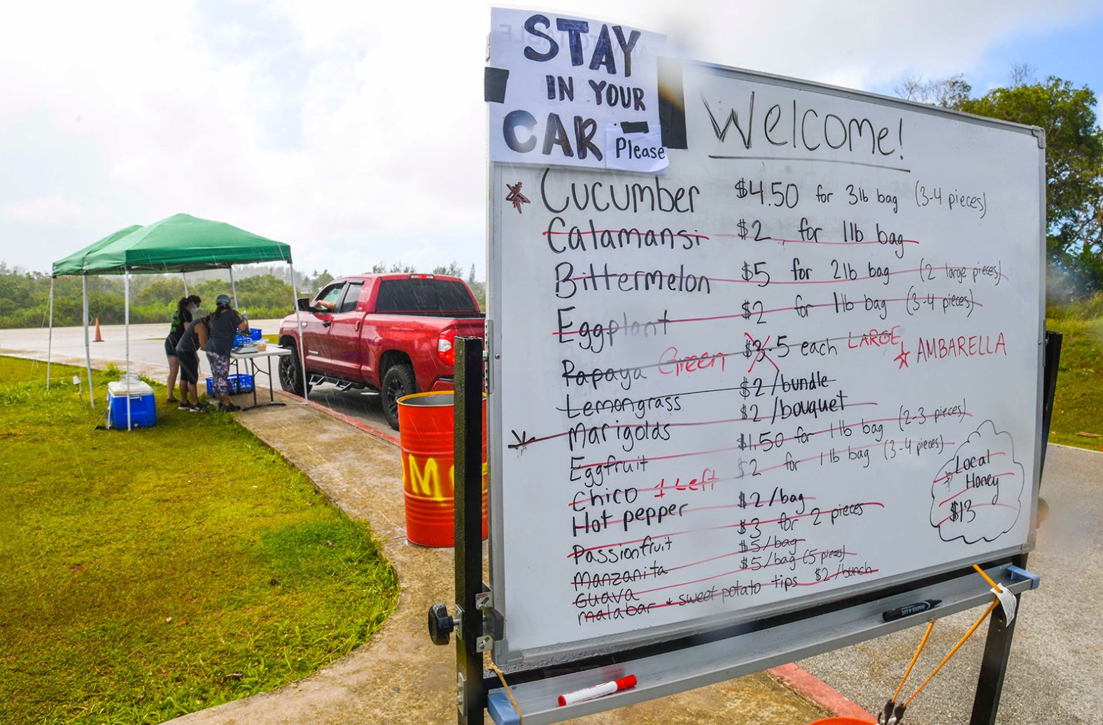 Items are crossed out on a whiteboard during a drive-thru produce sale at the Farmer's Co-op in Dededo, Guam, on April 23. <a href="index.php?page=&url=https%3A%2F%2Fwww.guampdn.com%2Fstory%2Fmoney%2F2020%2F04%2F21%2Fguam-farmers-market-farm-totable%2F5169151002%2F" target="_blank" target="_blank">The event,</a> put together by the nonprofit group Farm to Table Guam, offered produce grown by local farmers and was set to run for four hours. But it was cut short because the majority of the produce was sold in about half the time.