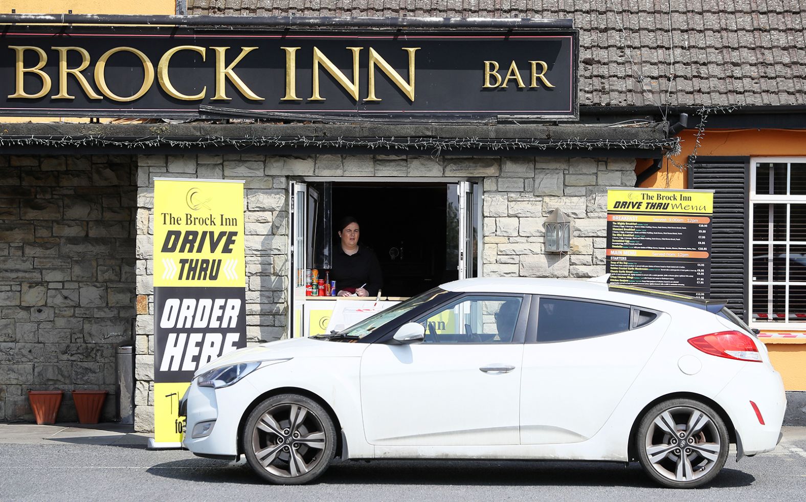 Staff member Lauren Byrne takes orders at The Brock Inn in County Dublin, Ireland, on April 25. The inn set up a drive-thru service to provide breakfast, lunch and dinner.