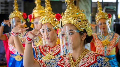 Traditional Thai dancers wearing protective face shields perform at the Erawan Shrine, which was reopened after the Thai government relaxed measures to combat the spread of the COVID-19 novel coronavirus, in Bangkok on May 4, 2020. - Thailand began easing restrictions related to the COVID-19 novel coronavirus on May 3 by allowing various businesses to reopen, but warned that the stricter measures would be re-imposed should cases increase again. (Photo by Mladen ANTONOV / AFP) (Photo by MLADEN ANTONOV/AFP via Getty Images)