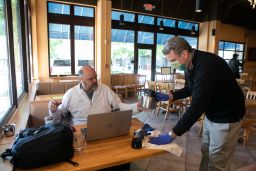 Manager cleans up a customer's table in the dining room of a restaurant that now offers dine-in service in Georgia. 