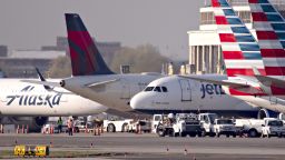 A JetBlue Airways Corp. plane taxis next to American Airlines Group Inc., Delta Air Lines Inc., and Alaska Airlines Inc. aircraft at Reagan National Airport (DCA) in Arlington, Virginia, U.S., on Monday, April 6, 2020. U.S. airlines are applying for federal aid to shore up their finances as passengers stay home amid the coronavirus pandemic. Photographer: Andrew Harrer/Bloomberg via Getty Images