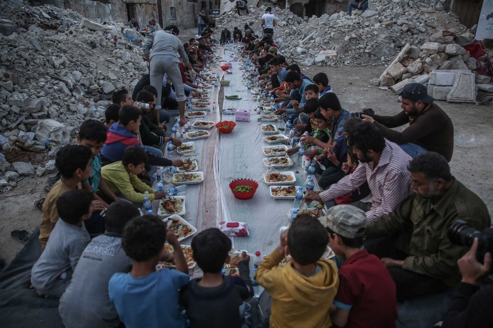 People break fast amid destroyed buildings in Al Atarib, Syria, on May 7.