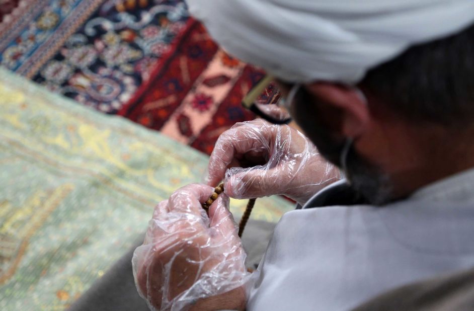 An imam counts beads at the Imam Sadiq Mosque in Abyek, Iran, on May 7. The Iranian government had just announced the reopening of mosques in areas of lower risk.