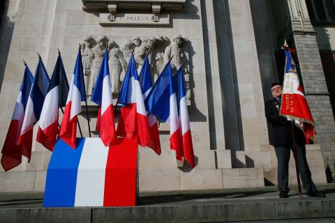 A veteran holds a French flag before a ceremony in Lille, France.