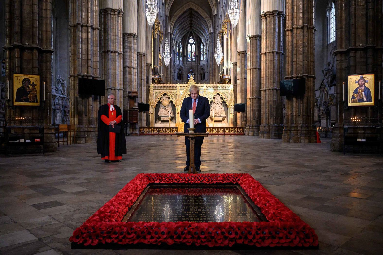 British Prime Minister Boris Johnson lights a candle at the grave of the Unknown Warrior in London's Westminster Abbey.