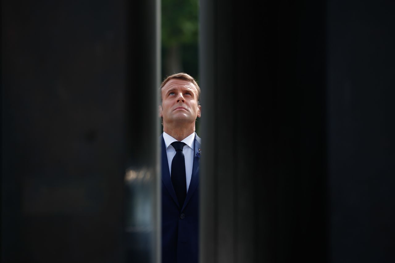 French President Emmanuel Macron looks up at the statue of Charles de Gaulle during VE Day ceremonies in Paris.