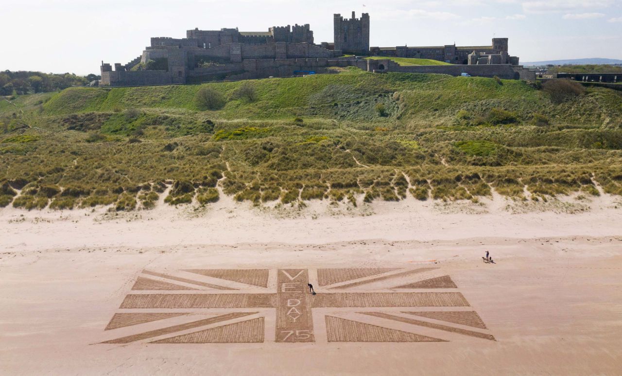 Andrew Heeley, a maintenance manager at Bamburgh Castle, draws a giant Union Jack flag on a beach in Northumberland, England.