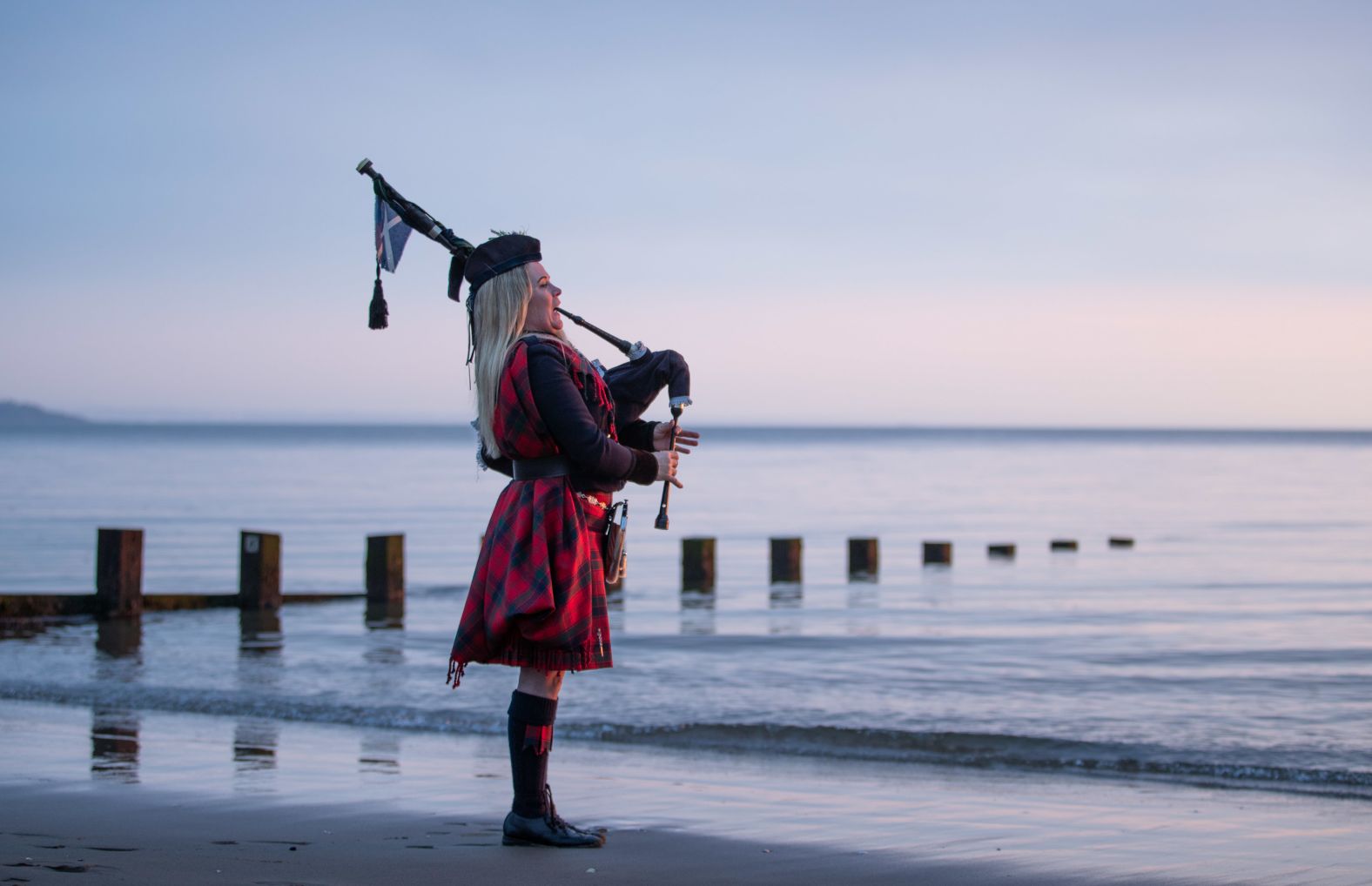 Louise Marshall plays the bagpipes at dawn along Portobello Beach in Edinburgh, Scotland.