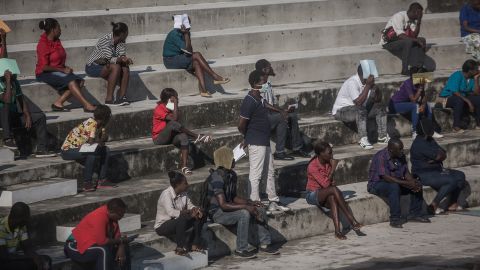 People attempt to social distance as they wait in line in downtown Port-au-Prince on March 26, 2020 (Photo by Pierre Michel Jean / AFP)