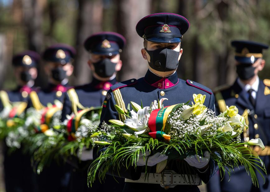 Soldiers wear protective face masks at a VE Day memorial in Vilnius, Lithuania, on Friday, May 8.