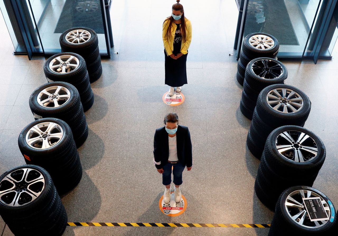 People stand on social-distancing markers at a Mercedes-Benz car dealership in Brussels, Belgium, on May 6.