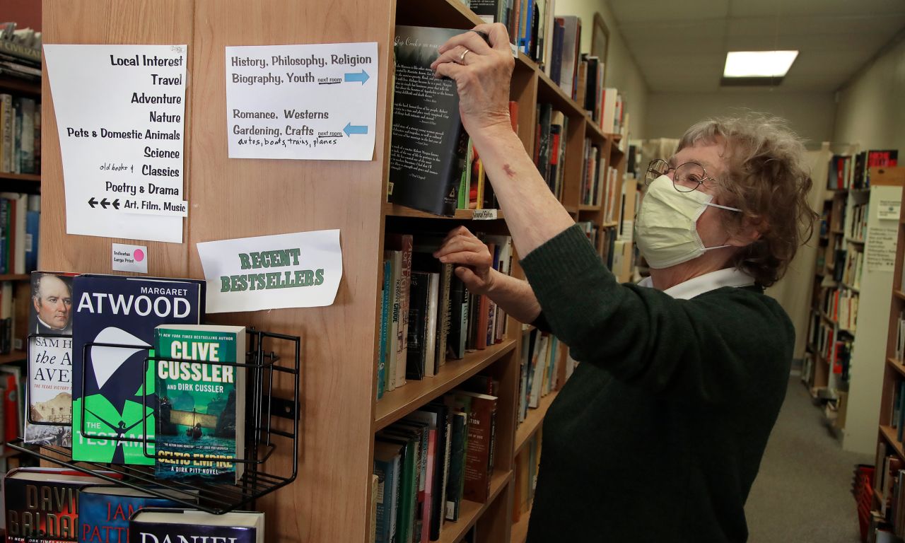 Sue Conklin, owner of Books Rio V, stocks her shelves in Rio Vista, California, on May 8. It was her first day back at the used bookstore since March 28.