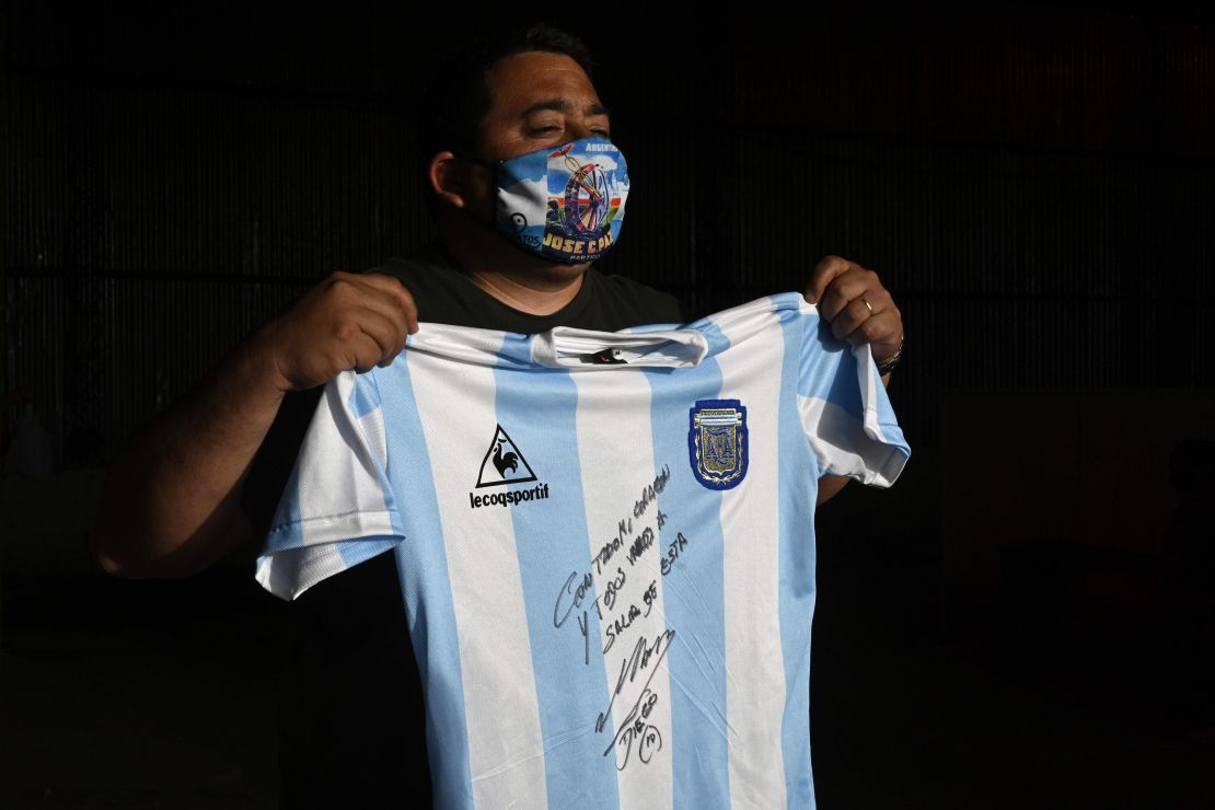A man holds a replica of Argentina's football team jersey used during the final of the 1986 World Cup and signed by Diego Maradona.