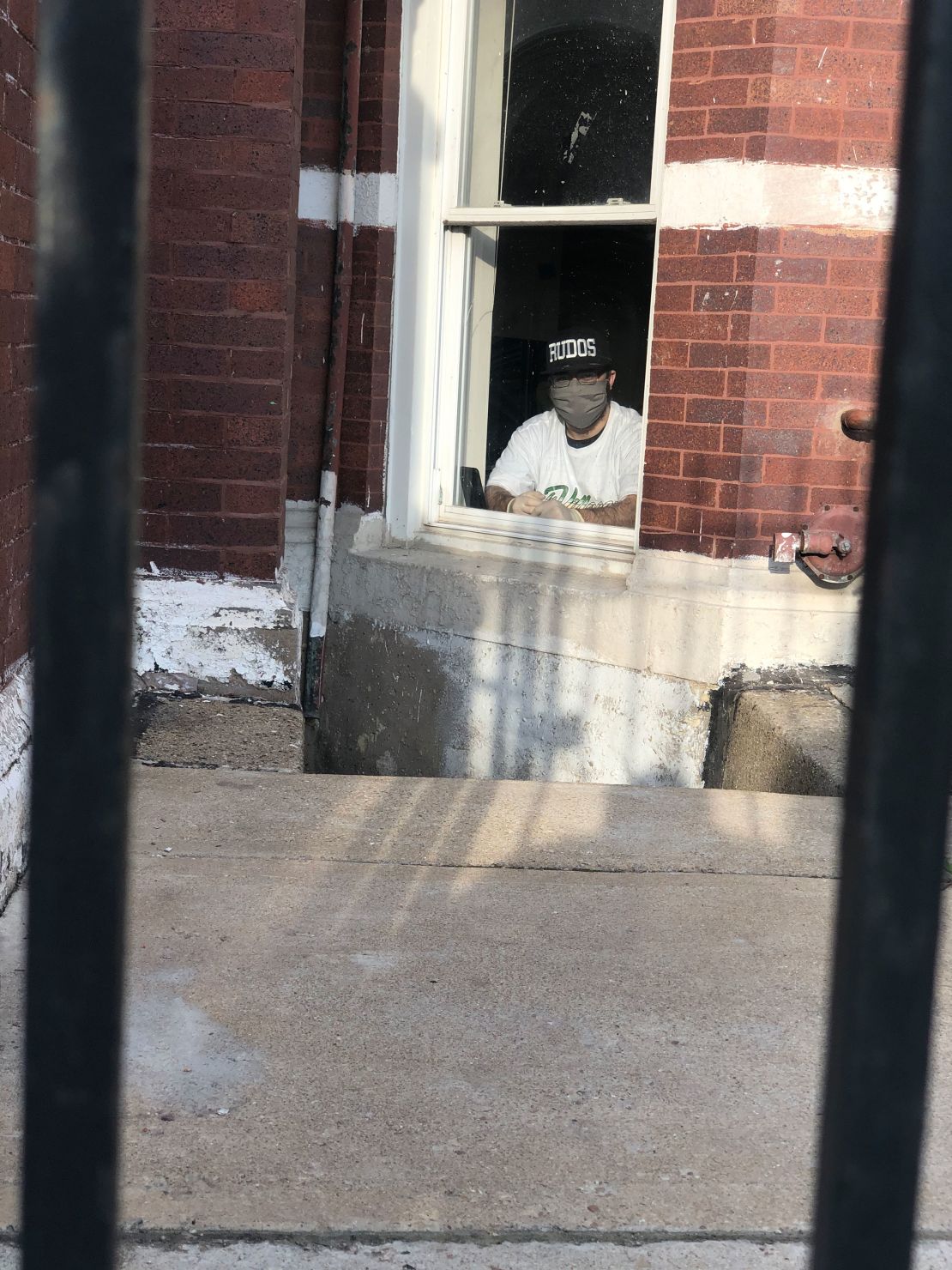 Alex "Demo" Ramirez speaks to CNN through the window of his basement apartment. He was diagnosed with Covid-19 on May 1.