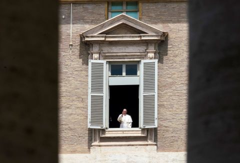 Pope Francis delivers a blessing from the window of his studio overlooking an empty St. Peter's Square.