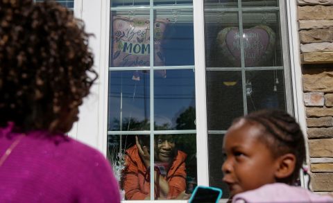 Mary Washington speaks through a window to her daughter Courtney Crosby and grandchild Sydney Crosby during a Mother's Day celebration at her senior-living facility in Smyrna, Georgia.
