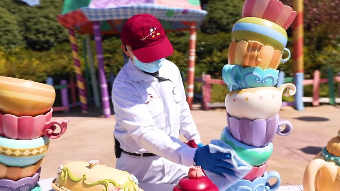 A worker sanitizes the Alice in Wonderland walk-through maze.