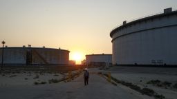 An employee walks past crude oil storage tanks at the Juaymah Tank Farm in Saudi Aramco's Ras Tanura oil refinery and oil terminal in Ras Tanura, Saudi Arabia, on Monday, Oct. 1, 2018. Saudi Arabia is seeking to transform its crude-dependent economy by developing new industries, and is pushing into petrochemicals as a way to earn more from its energy deposits. Photographer: Simon Dawson/Bloomberg via Getty Images